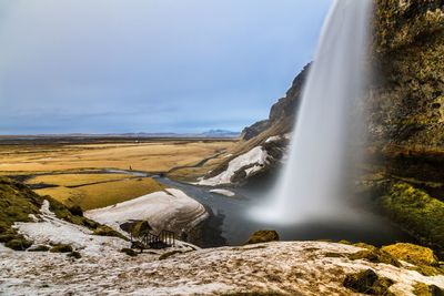 Scenic view of waterfall against sky