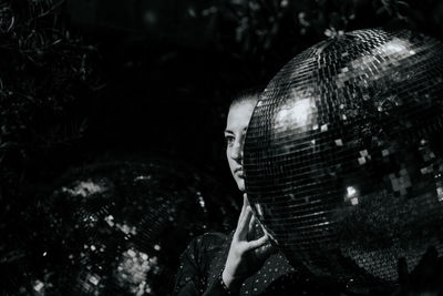 Close-up of man holding ball against trees