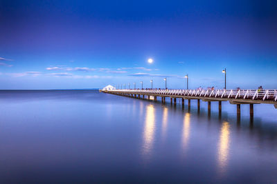 Pier over sea against blue sky