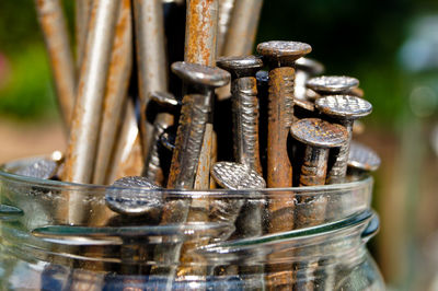 Close-up of nails in glass jar on table