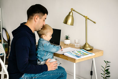 Side view of mother and daughter sitting at home