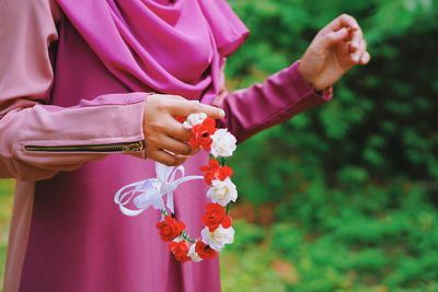 Midsection of woman holding floral headband