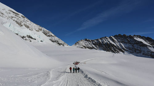 Tourists on snow covered mountain