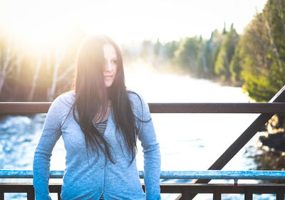 Woman leaning against railing in sun