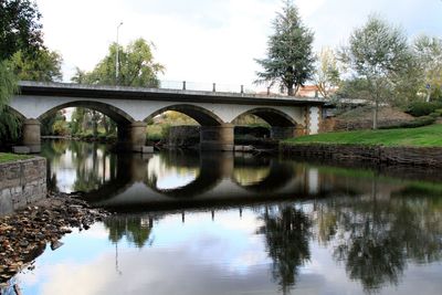 Arch bridge over river against sky