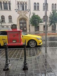 Red car on street against buildings in city