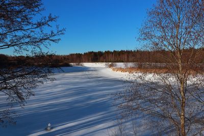 Scenic view of lake against clear blue sky