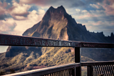 Close-up of text on railing against mountain