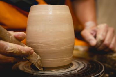 Cropped hands of potter making pot