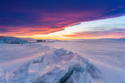 Scenic view of snow landscape against sky during sunset
