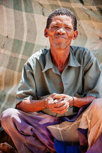Portrait of smiling man sitting outdoors