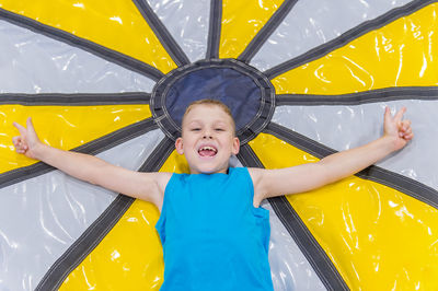 Full length of happy girl with yellow umbrella