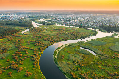 High angle view of river amidst field against sky