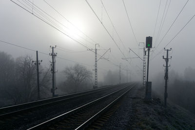 Railroad tracks against sky during winter