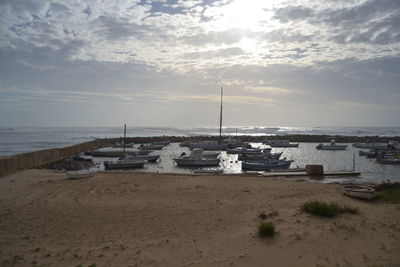 Sailboats on beach against sky