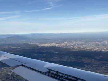 Airplane flying over landscape against sky