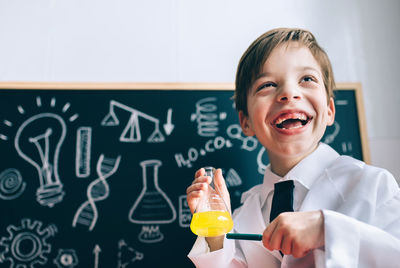 Boy wearing lap coat while standing in classroom