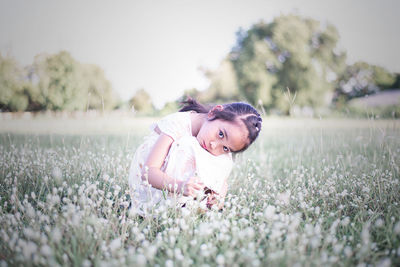 Portrait of girl with flowers on field