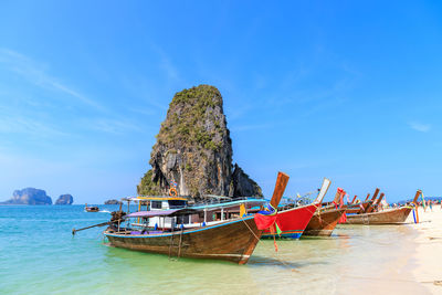 Boat moored on beach against sky