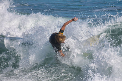 Rear view of man swimming in sea