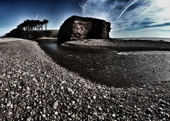 Rock formations against cloudy sky