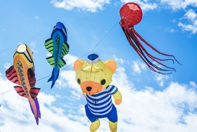 Low angle view of toys hanging against sky