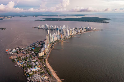High angle view of city by sea against sky