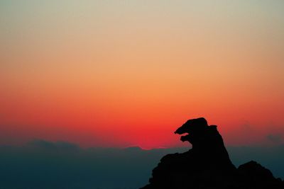 Silhouette of rock against sky during sunset