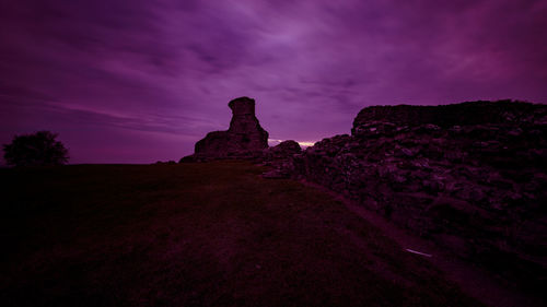 Low angle view of rock formation against sky at sunset