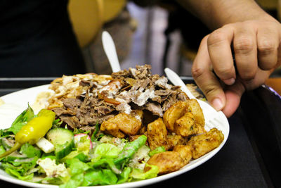 Waiter in restaurant brings food dish on table