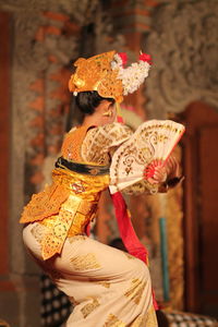 Woman in traditional clothing performing during event