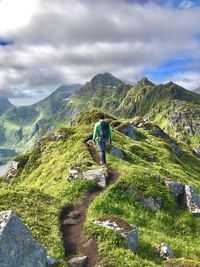 Rear view of woman walking on mountain against sky