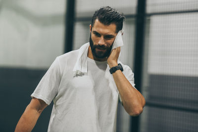 Man playing padel tennis wipes the sweat. sporty boy at the end of the match. sweaty barded athlete 