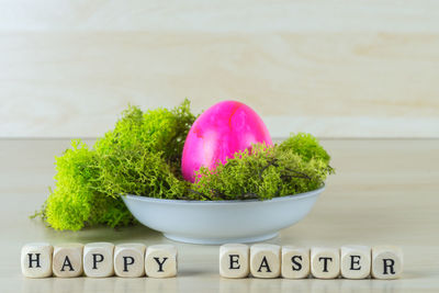 Close-up of text by easter eggs and vegetable on table