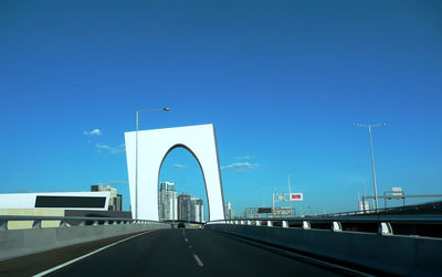 View of highway against clear blue sky