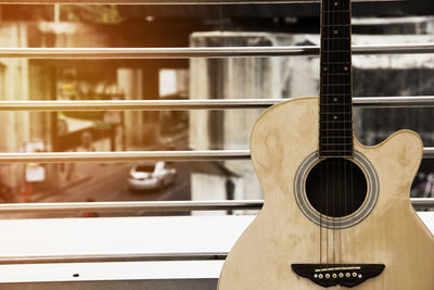 Close-up of guitar against railing on balcony