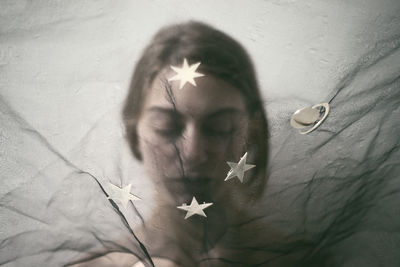 Close-up portrait of young woman against white wall