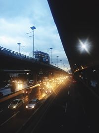 Cars on road in city against sky at night