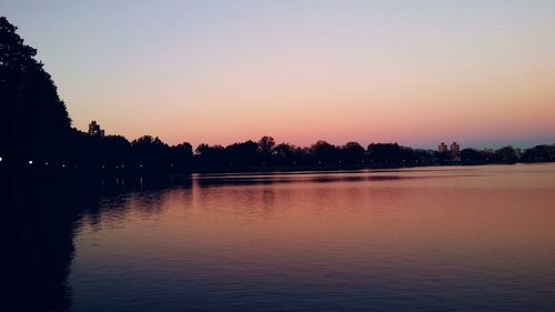 Scenic view of lake against clear sky during sunset