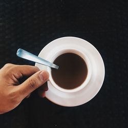 Directly above shot of hand holding coffee cup