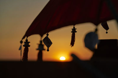 Close-up of illuminated lamp against sky at sunset