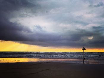 Scenic view of beach against dramatic sky
