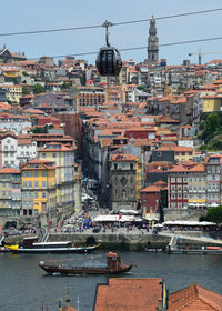 Sailboats moored at harbor against buildings in city