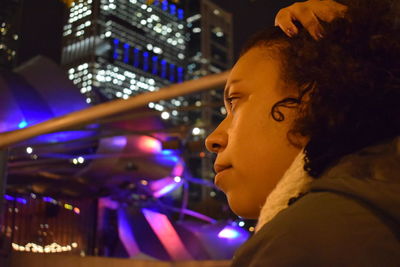 Close-up of woman with hand in hair and looking away