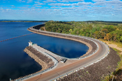 High angle view of swimming pool by river against sky