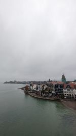 Buildings by sea against sky in city