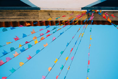 Low angle view of multi colored flags against sky