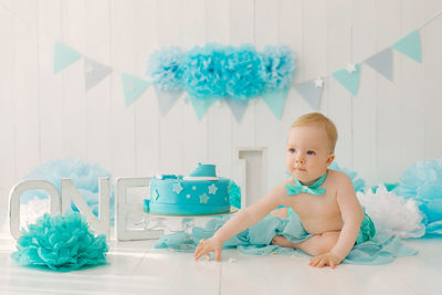 A one-year-old boy tries his first birthday cake. anniversary party