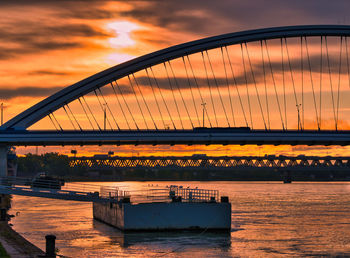 Bridge over sea against sky during sunset