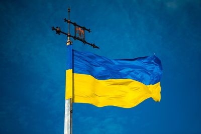 Low angle view of yellow flag against blue sky